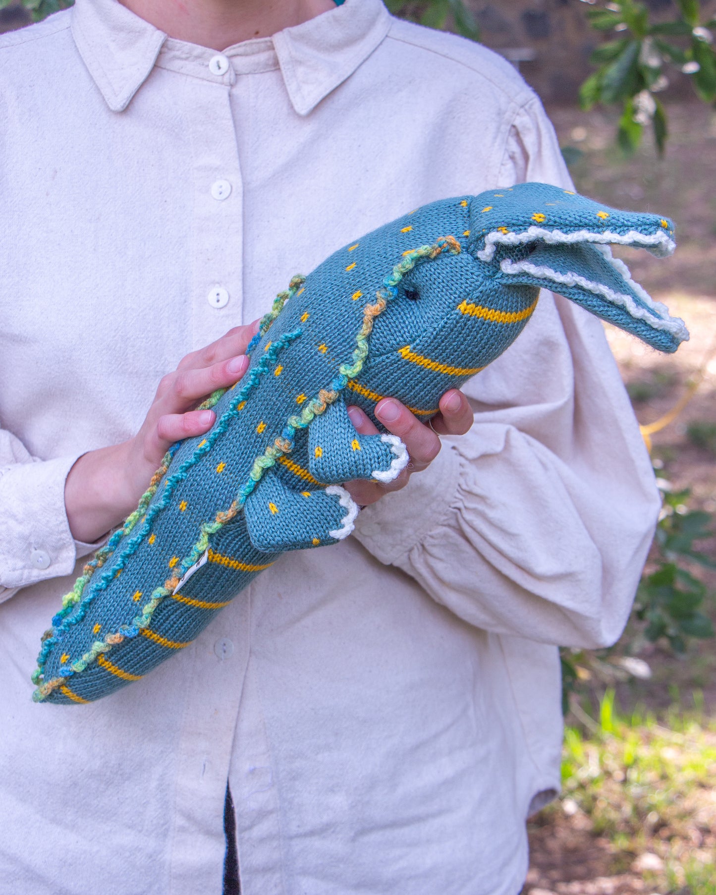 Cocodrilo de peluche en manos