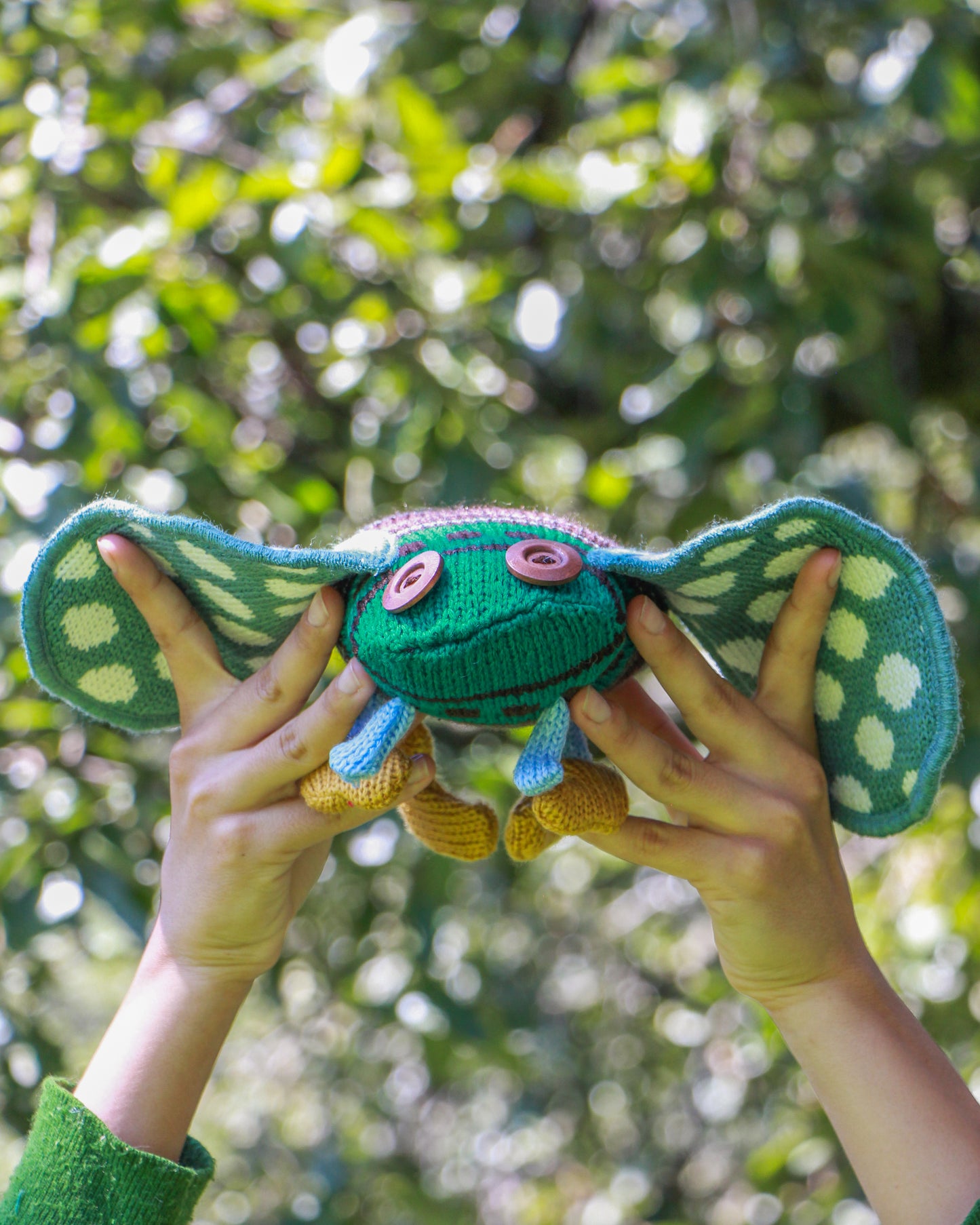 Chicharra de peluche verde en mano