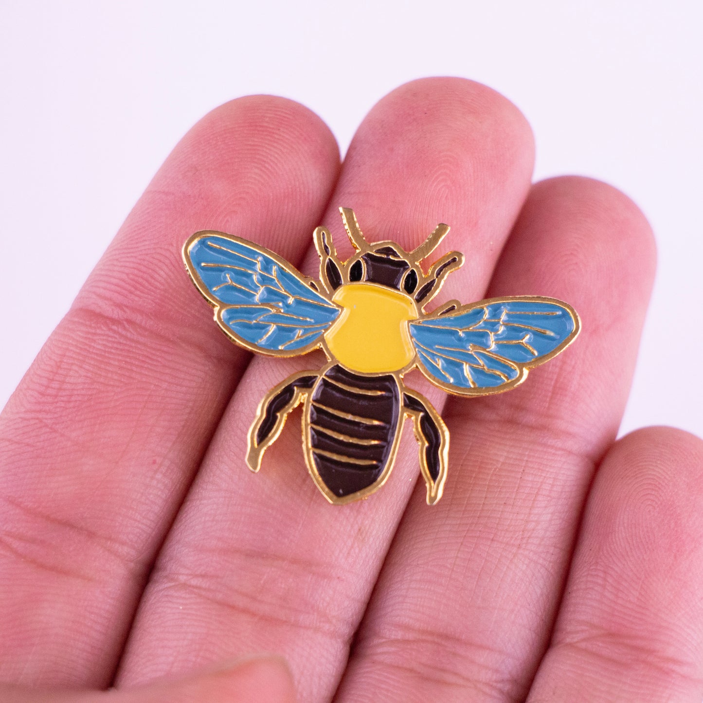 Pin de abeja en mano