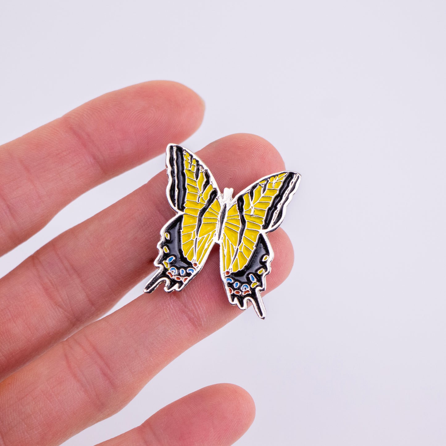 Pin de Mariposa Xochiquetzal en mano