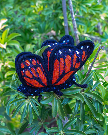 Mariposa monarca de peluche en plantas